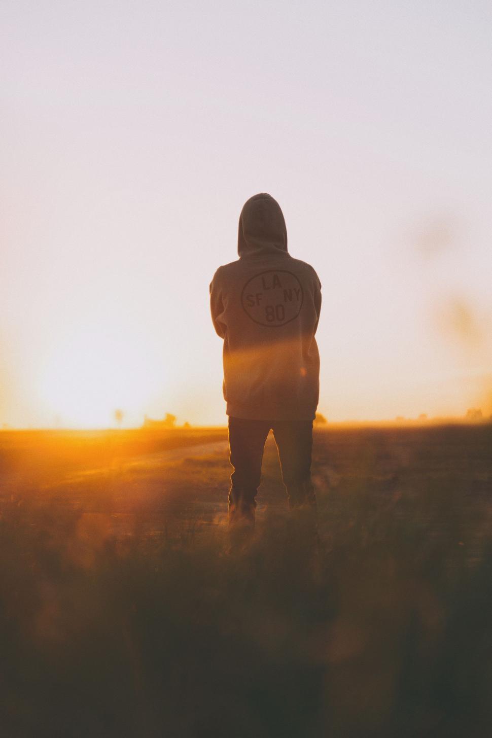 Free Image of Person Standing in Field at Sunset 