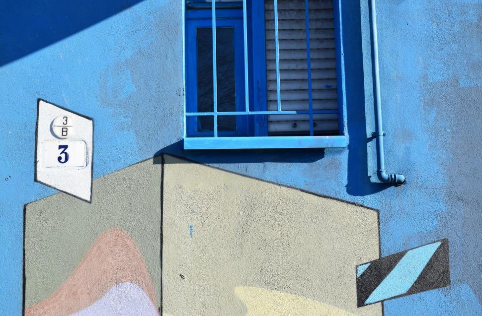 Free Image of Blue Building With Blue Window and White Sign 