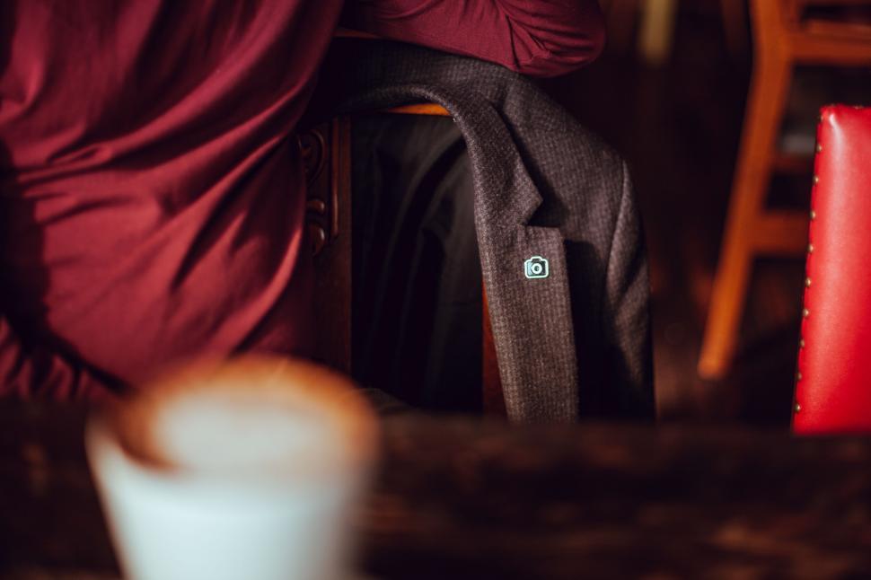 Free Image of Person Sitting at Table With Red Chair 
