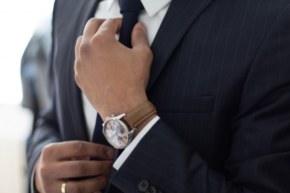 Free Image of Man in Suit Adjusting His Tie 