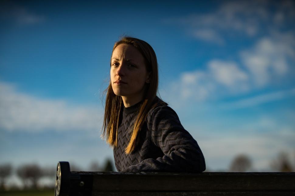 Free Image of Woman Sitting on Top of Wooden Bench 