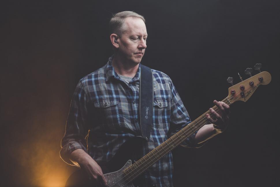 Free Image of Man Holding Guitar in Right Hand 