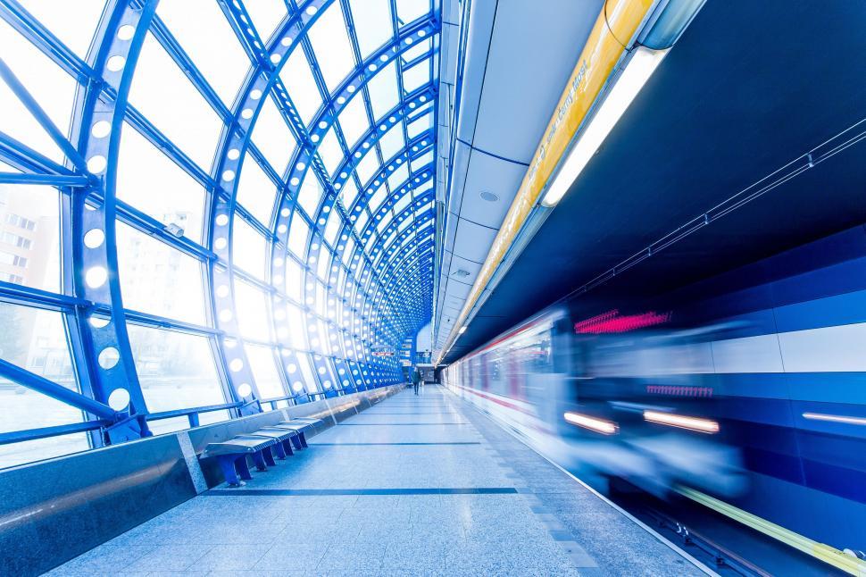 Free Image of Train Traveling Through Train Station Next to Loading Platform 