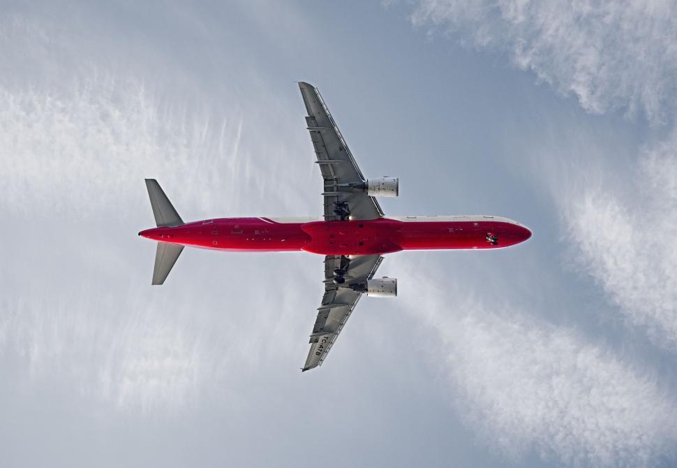Free Image of Airplane Flying in the Sky With Clouds in Background 