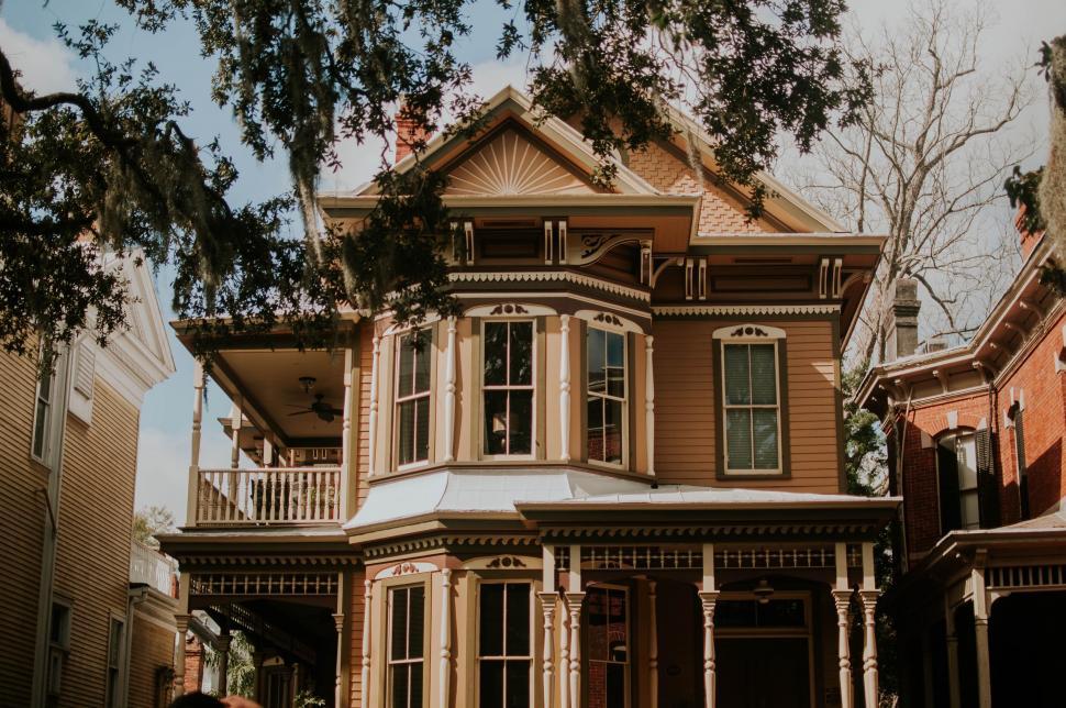 Free Image of Woman Standing in Front of Brown House 