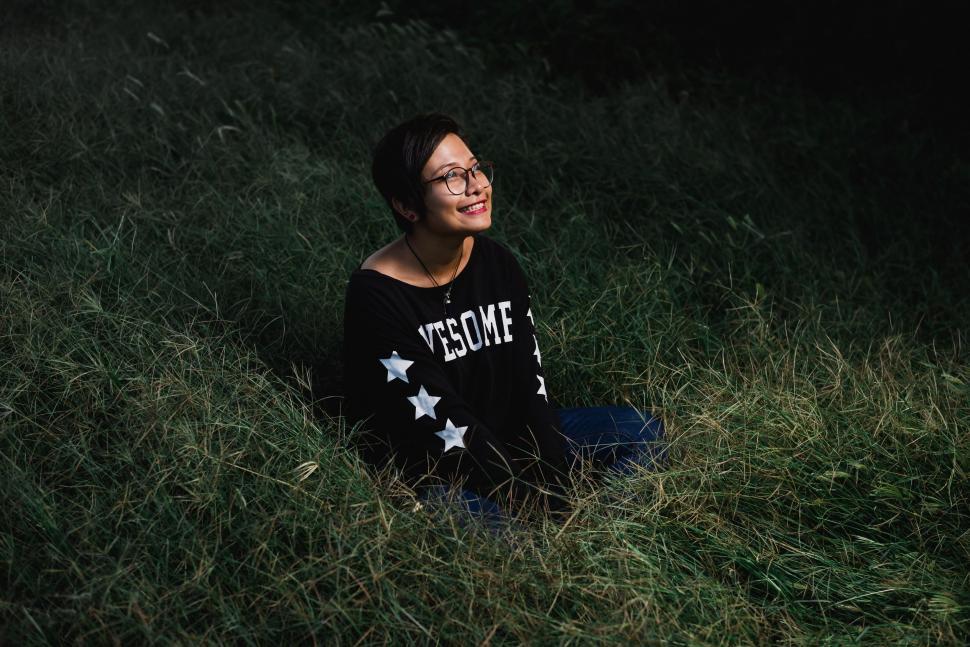 Free Image of Woman Sitting in Grass With Closed Eyes 