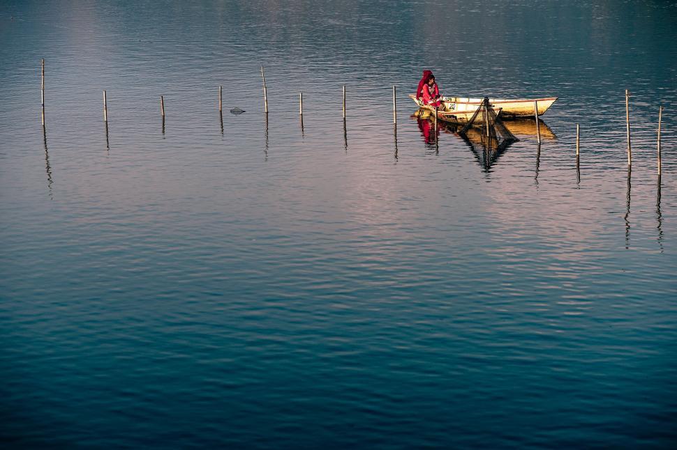 Free Image of Person Sitting in a Boat on a Lake 