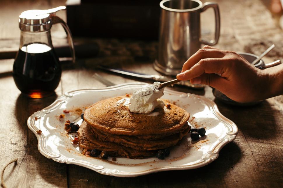 Free Image of Person Eating Stack of Pancakes on a Plate 