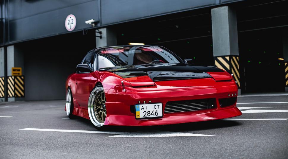 Free Image of Red Sports Car Parked in Parking Lot 