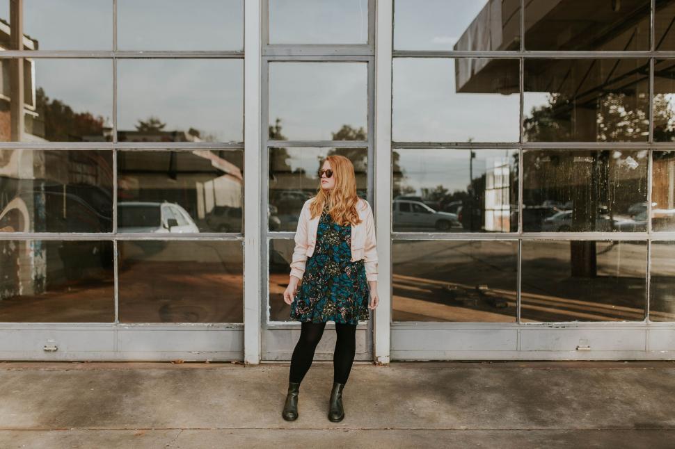 Free Image of Woman Standing in Front of Large Window 