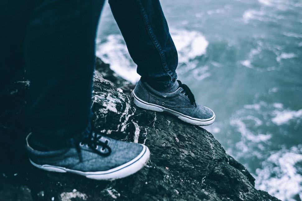Free Image of Person Standing on Top of Rock Near Ocean 