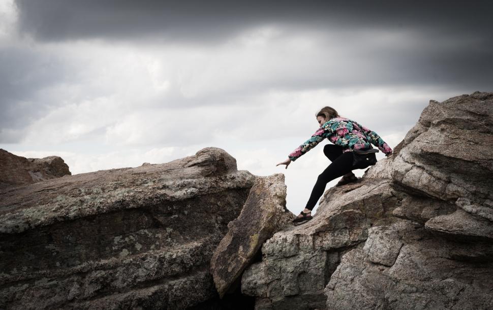 Free Image of Man Climbing Up the Side of a Large Rock 