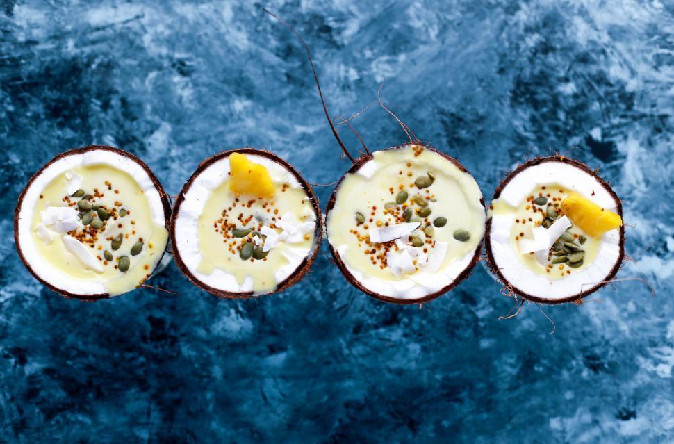 Free Image of Three Coconuts With Different Toppings on Blue Surface 