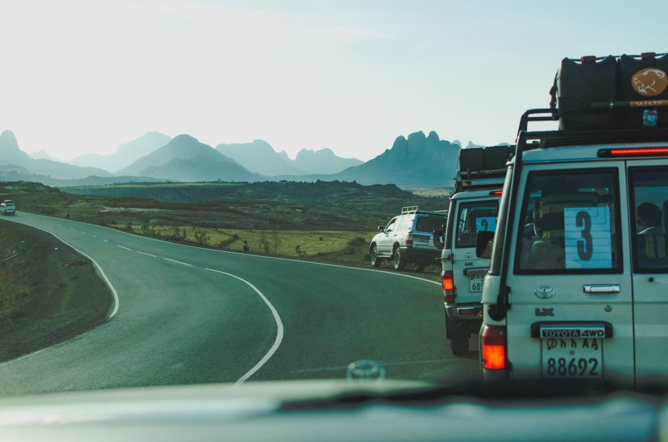Free Image of Cars Driving Down Road With Mountains Background 