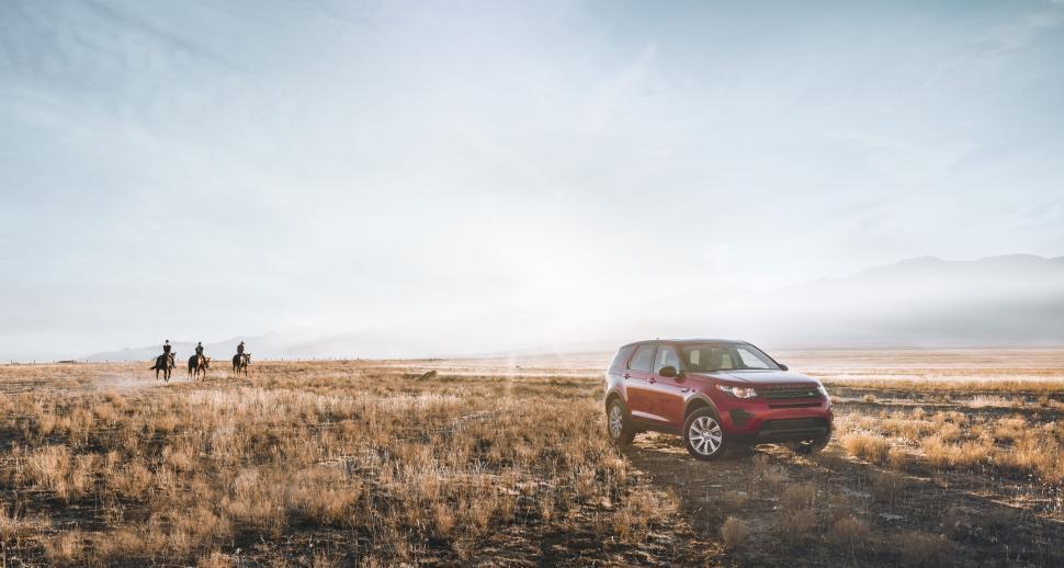 Free Image of Red Car Driving Down Dirt Road 