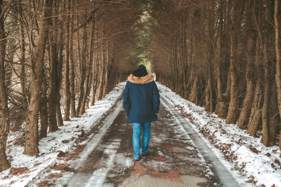 Free Image of Person Walking Down a Snow Covered Road 