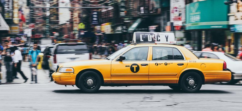 Free Image of Yellow Taxi Cab Driving Down City Street 