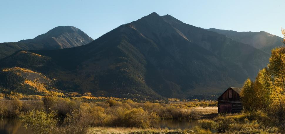 Free Image of House in a Field With Mountains in the Background 