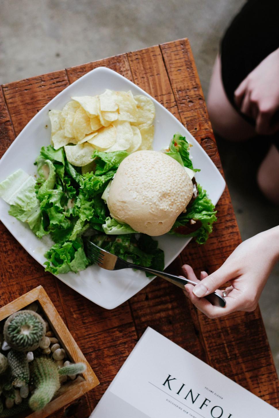 Free Image of Person Cutting Into a Sandwich With a Knife 