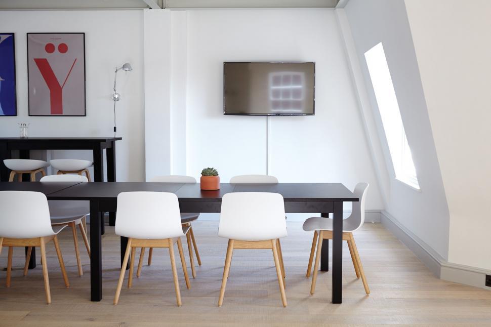 Free Image of Modern Living Room With Table, Chairs, and Television 