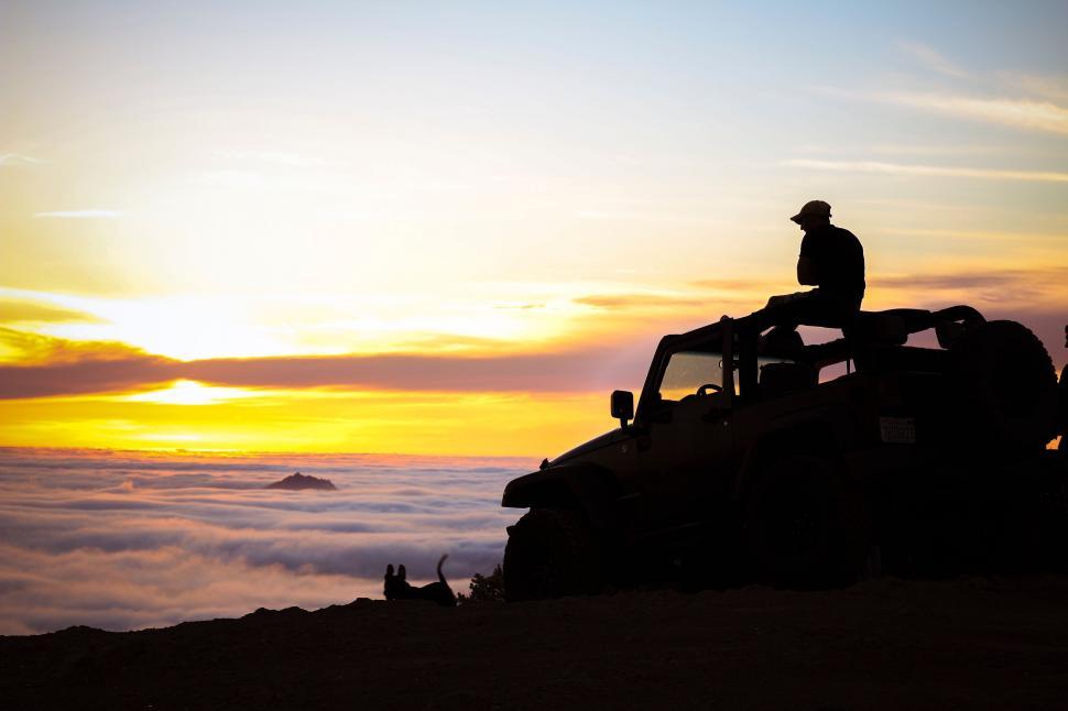 Free Image of Man Sitting on Vehicle on Mountain Top 
