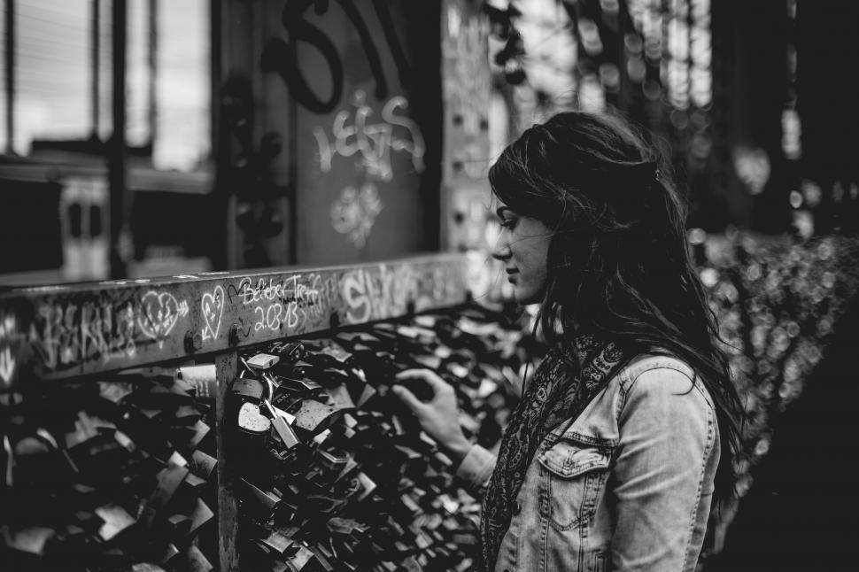 Free Image of Woman Standing Next to Fence Covered in Locks 