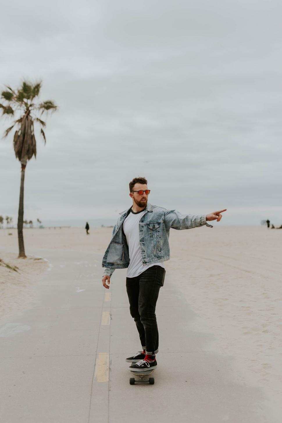 Free Image of Man Riding Skateboard on Sandy Beach 