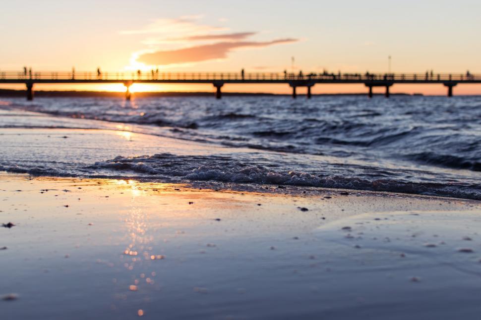 Free Image of Sun Setting Over Water at Beach 