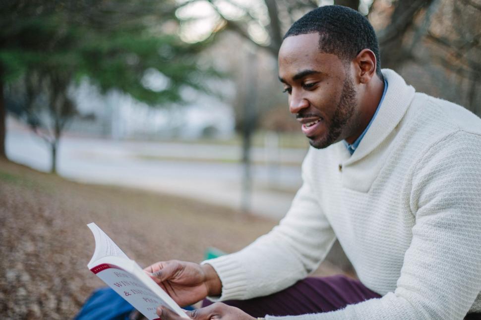 Free Image of Man Sitting on Bench Reading a Book 