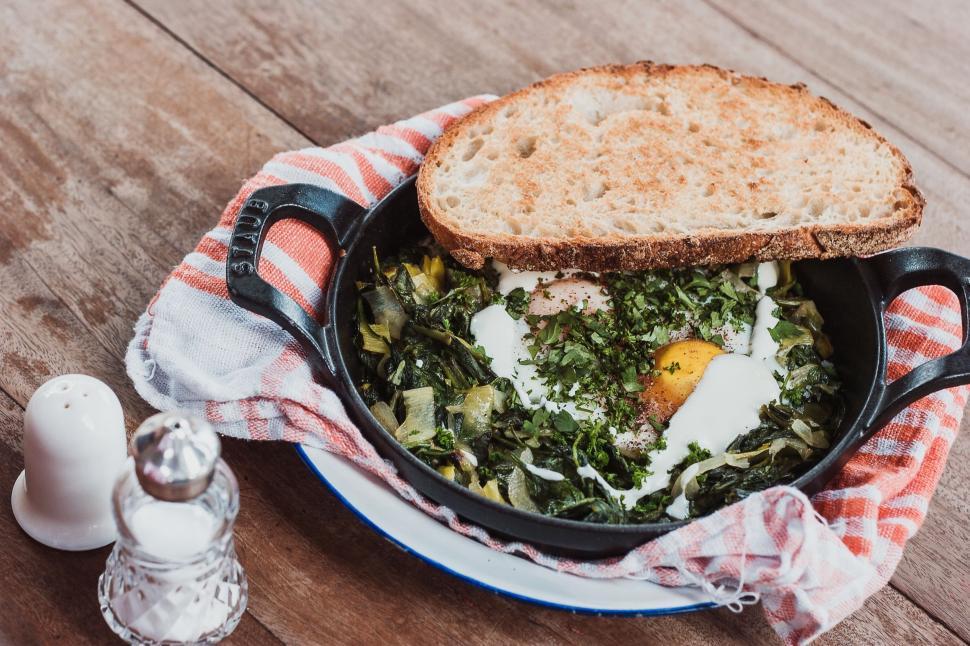 Free Image of A Bowl of Food With Bread and a Salt Shaker 