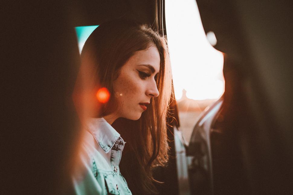 Free Image of Woman Sitting in Car Looking at Cell Phone 