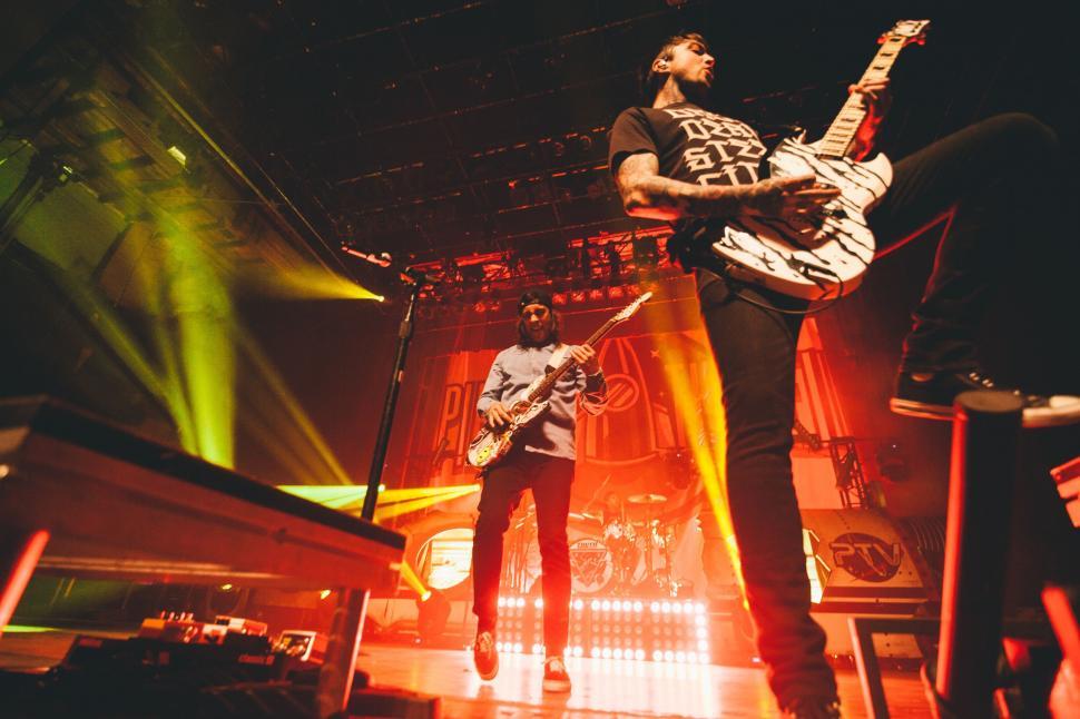 Free Image of Two Men Standing on Top of a Stage 