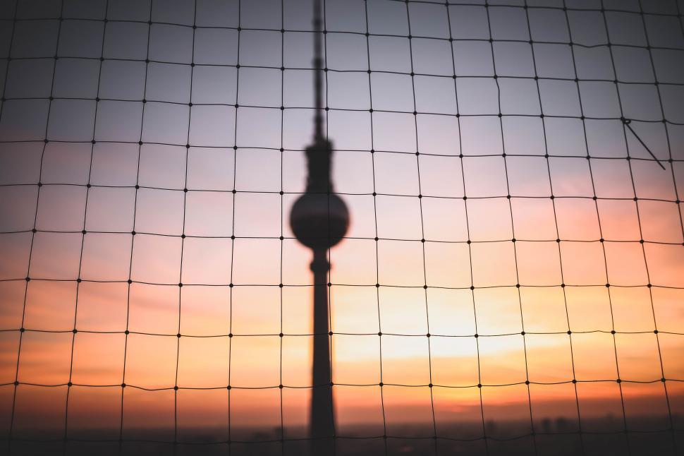 Free Image of Sun Setting Behind Wire Fence 