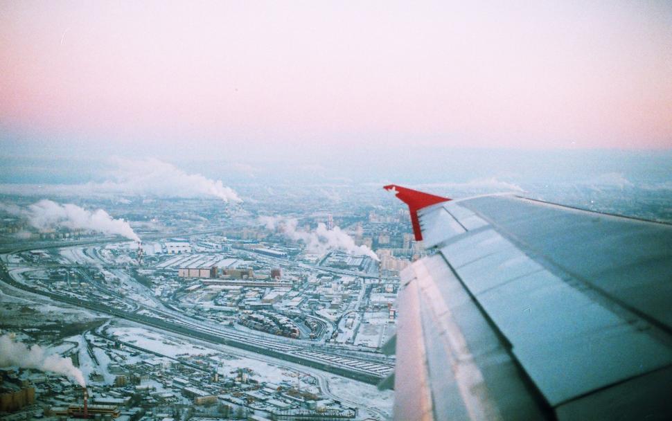 Free Image of Aircraft Wing Flying Over Cityscape 