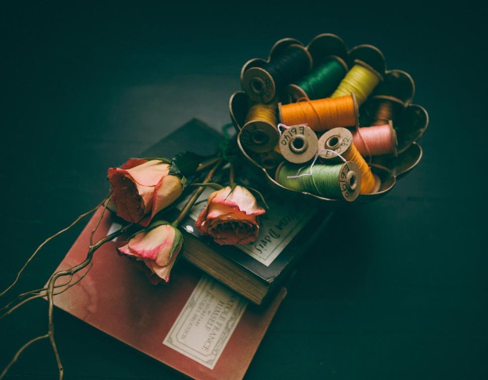Free Image of Spools of Thread on Top of a Book 