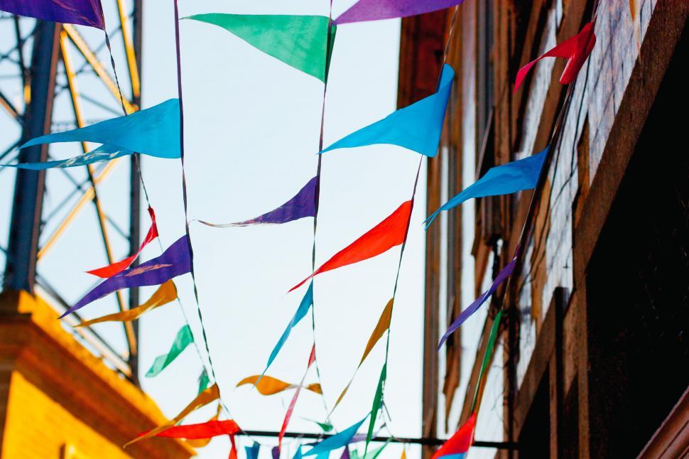 Free Image of Colorful Flags Hanging From Side of Building 