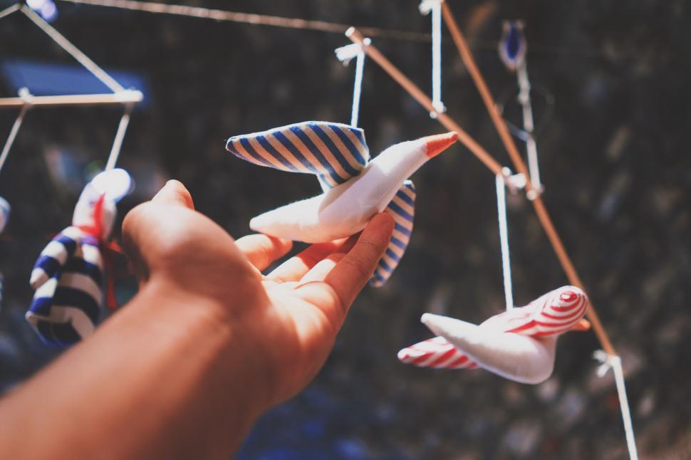 Free Image of Hand Holding String of Cloth Birds 