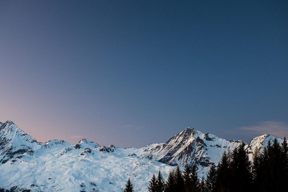 Free Image of Snow Covered Mountain With Trees in Foreground 