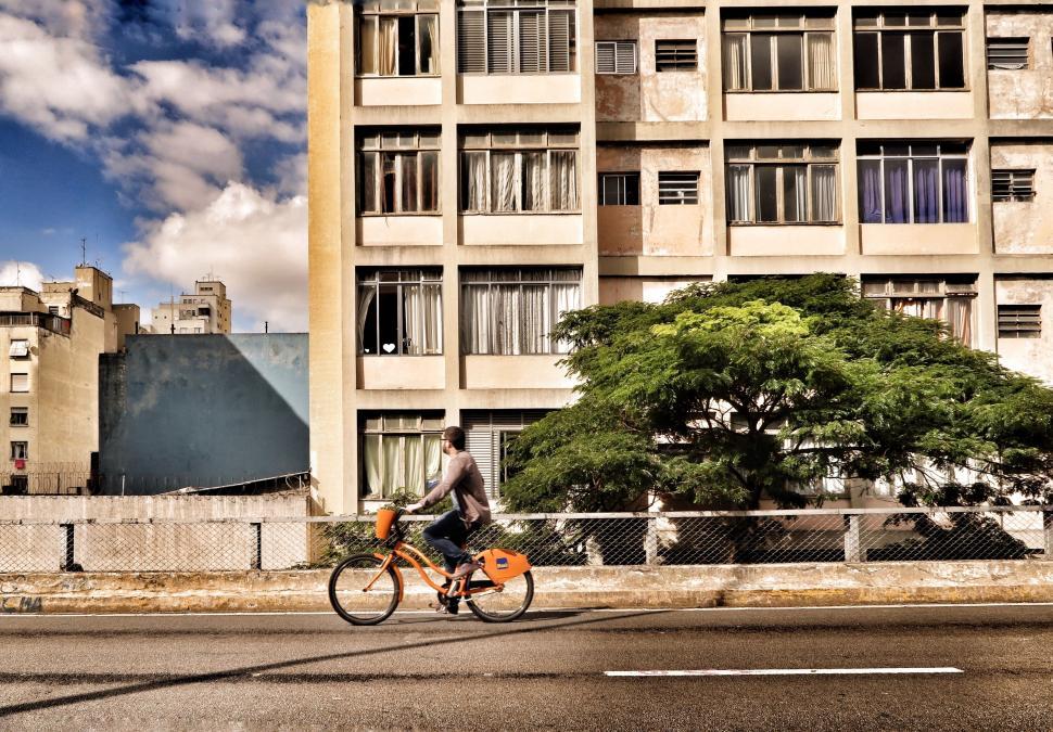 Free Image of Man Riding Bike Down City Street 
