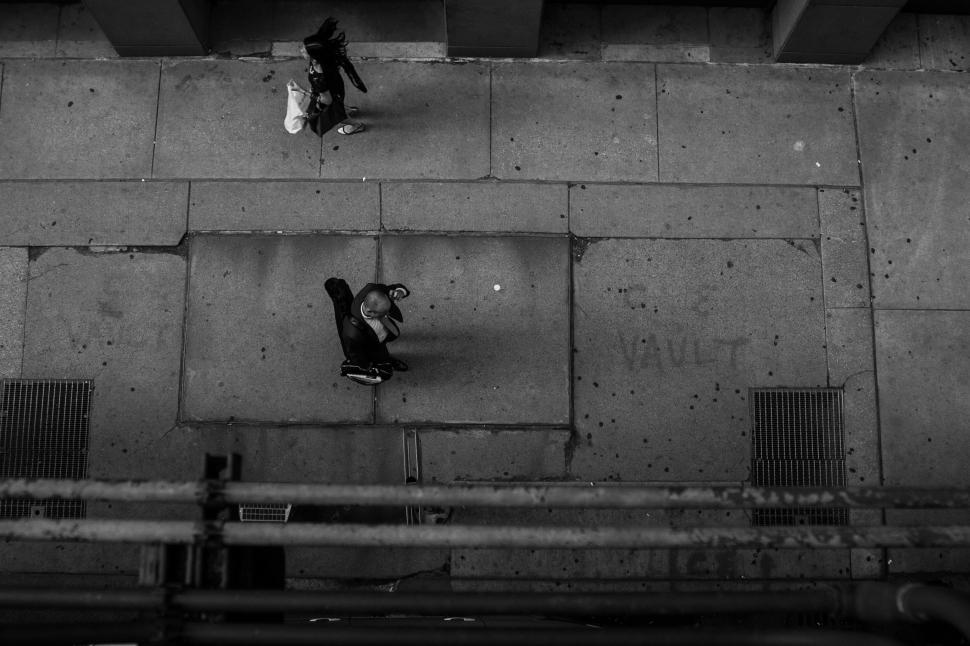Free Image of People Walking on Sidewalk in Black and White 