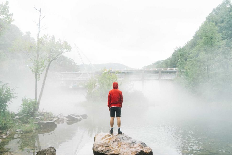Free Image of Person Standing on Rock in Middle of River 