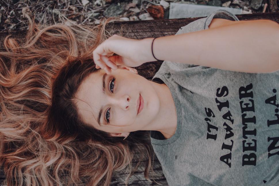 Free Image of Woman Laying on Ground Wearing Gray Shirt 