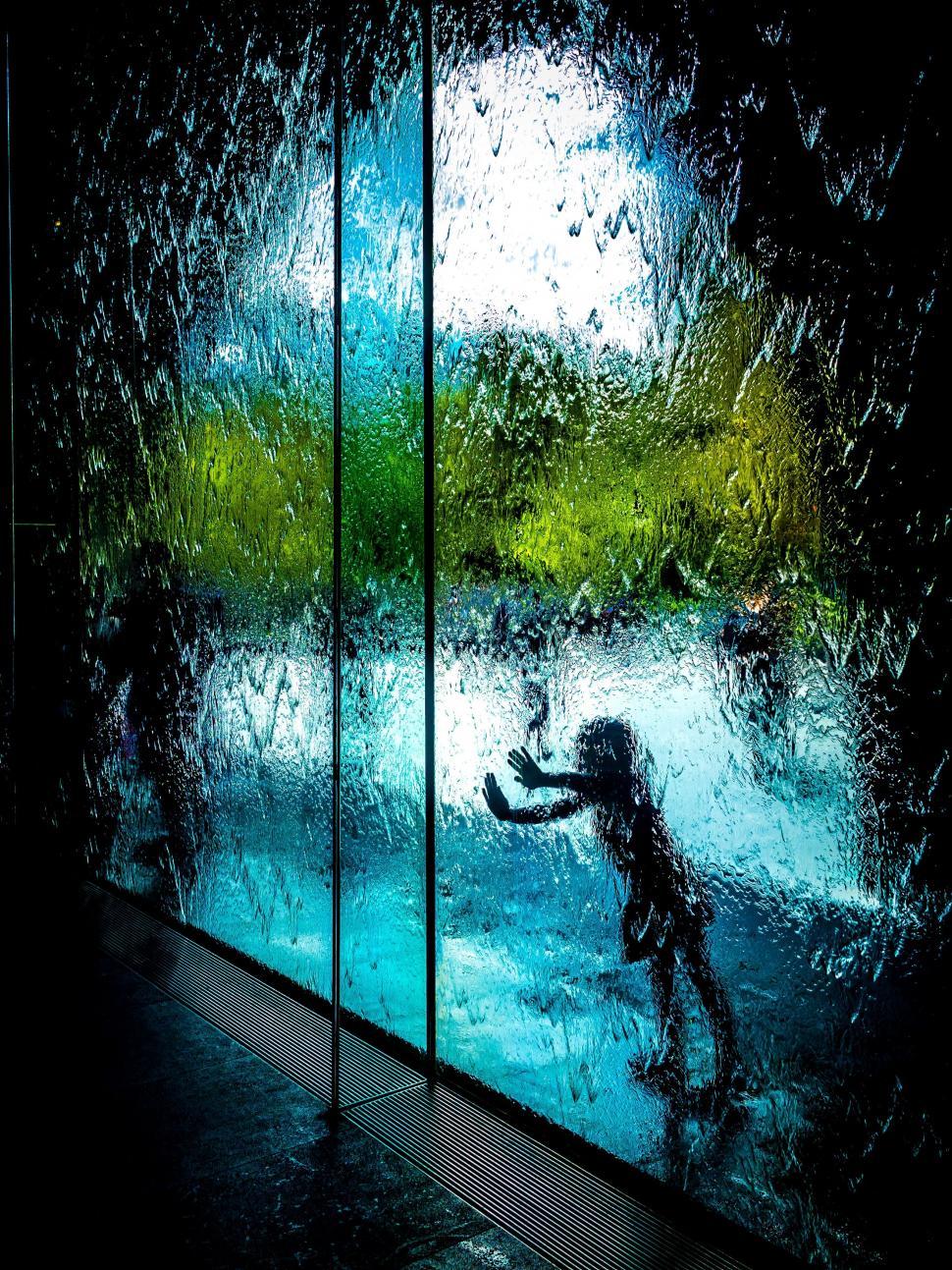 Free Image of Person Standing in Front of Glass Window 