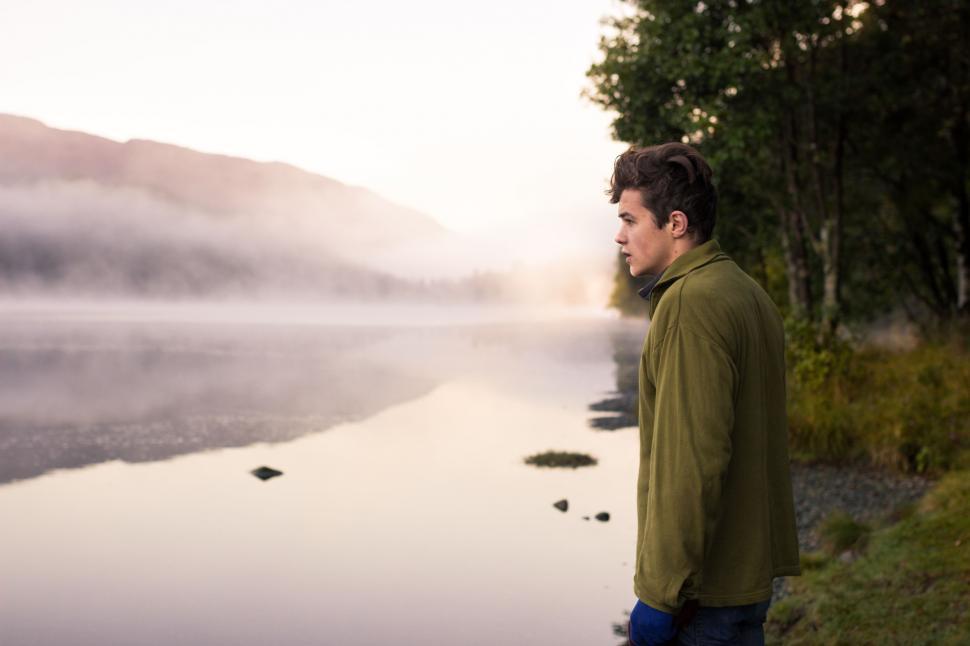 Free Image of Man Standing Next to Body of Water 