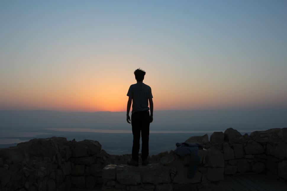 Free Image of Man Standing on Top of Rocky Hill 