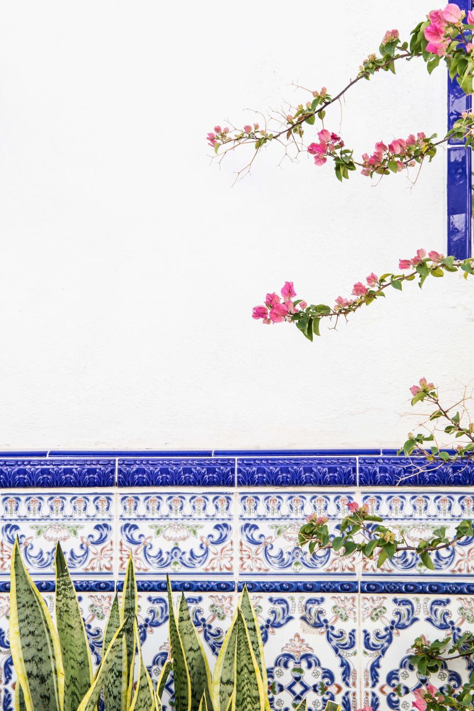 Free Image of Blue and White Tile Wall With Pink Flowers 