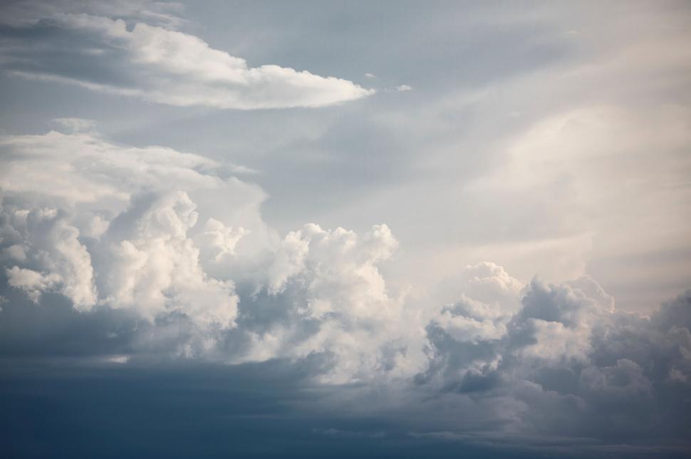 Free Image of Plane Flying Through Cloudy Blue Sky 