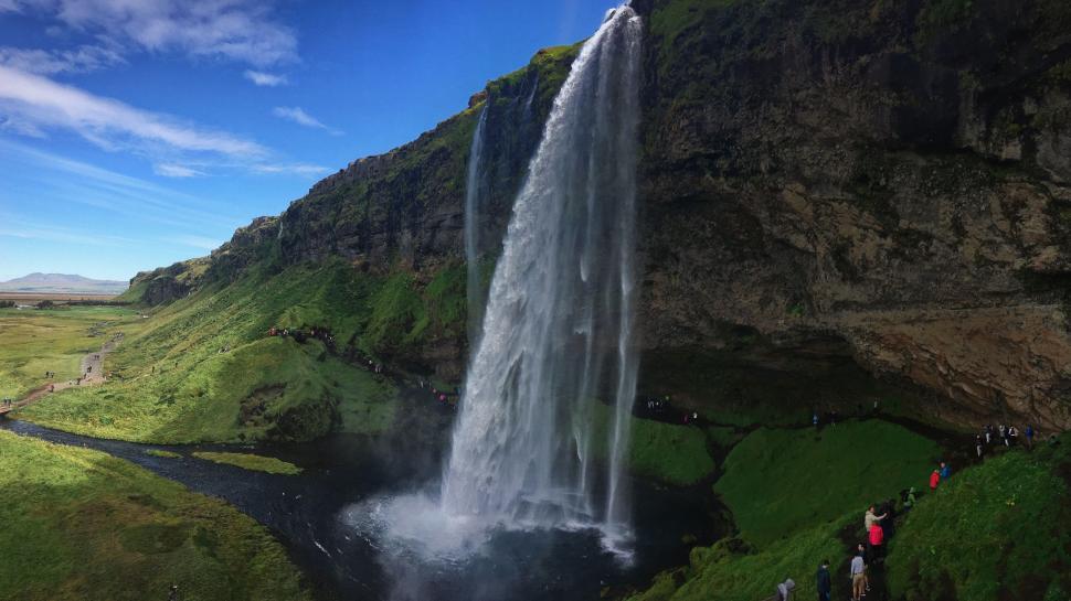 Free Image of Group of People Standing in Front of Waterfall 