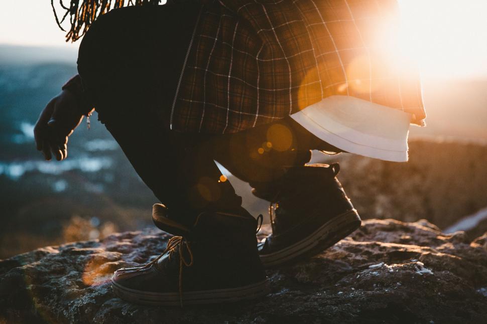 Free Image of Person Standing on Top of a Mountain Holding a Book 