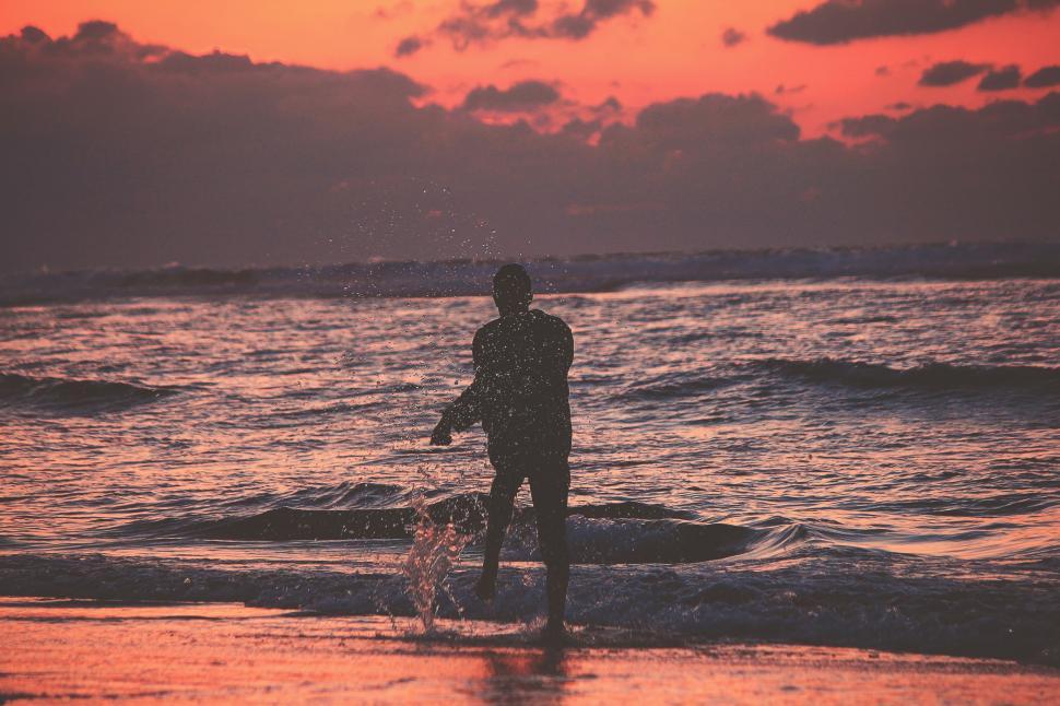 Free Image of Man Standing on Top of Beach Next to Ocean 